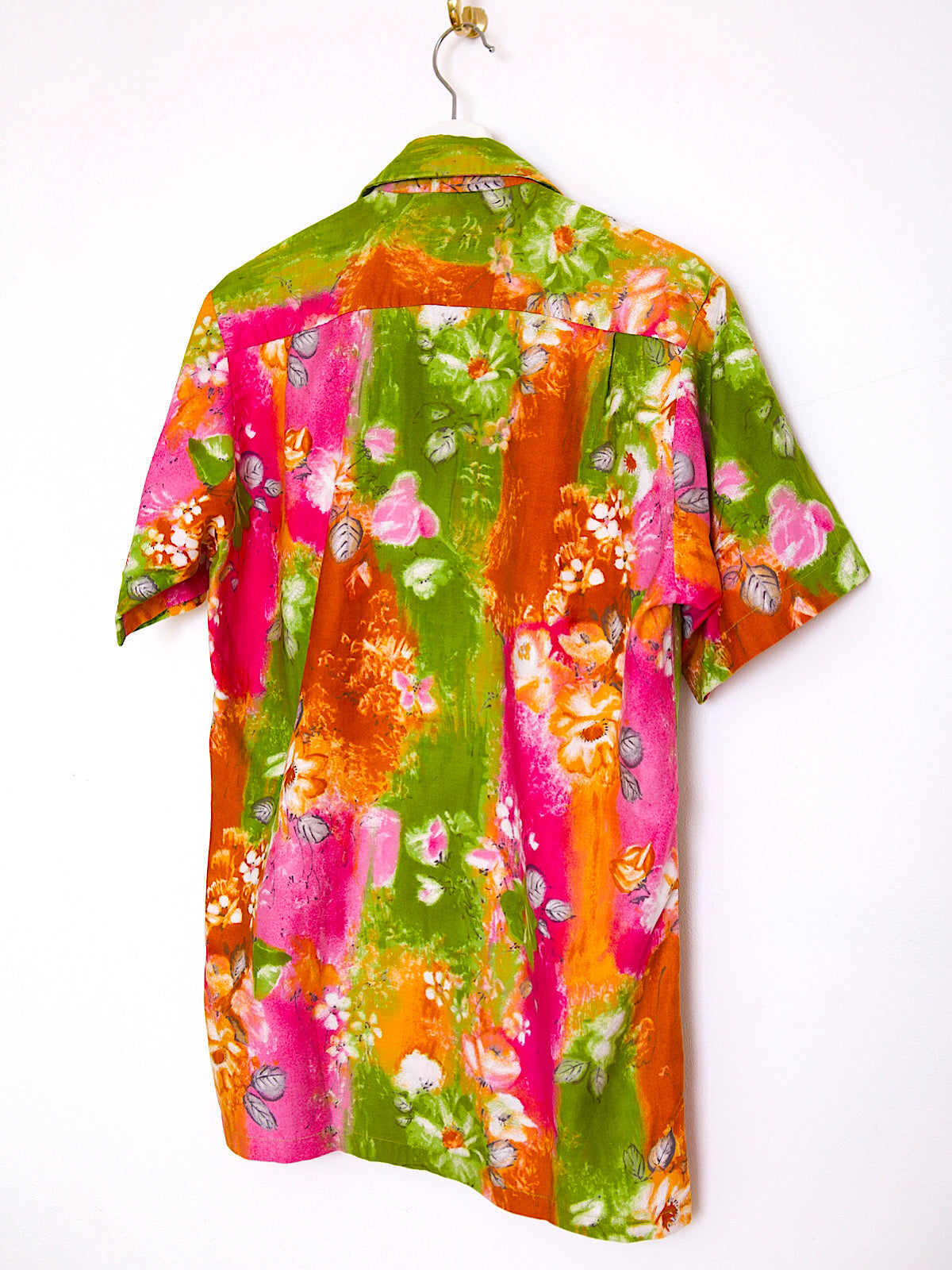Bright vintage 60s cotton Hawaiian shirt with green, orange, and pink floral print, short sleeves.